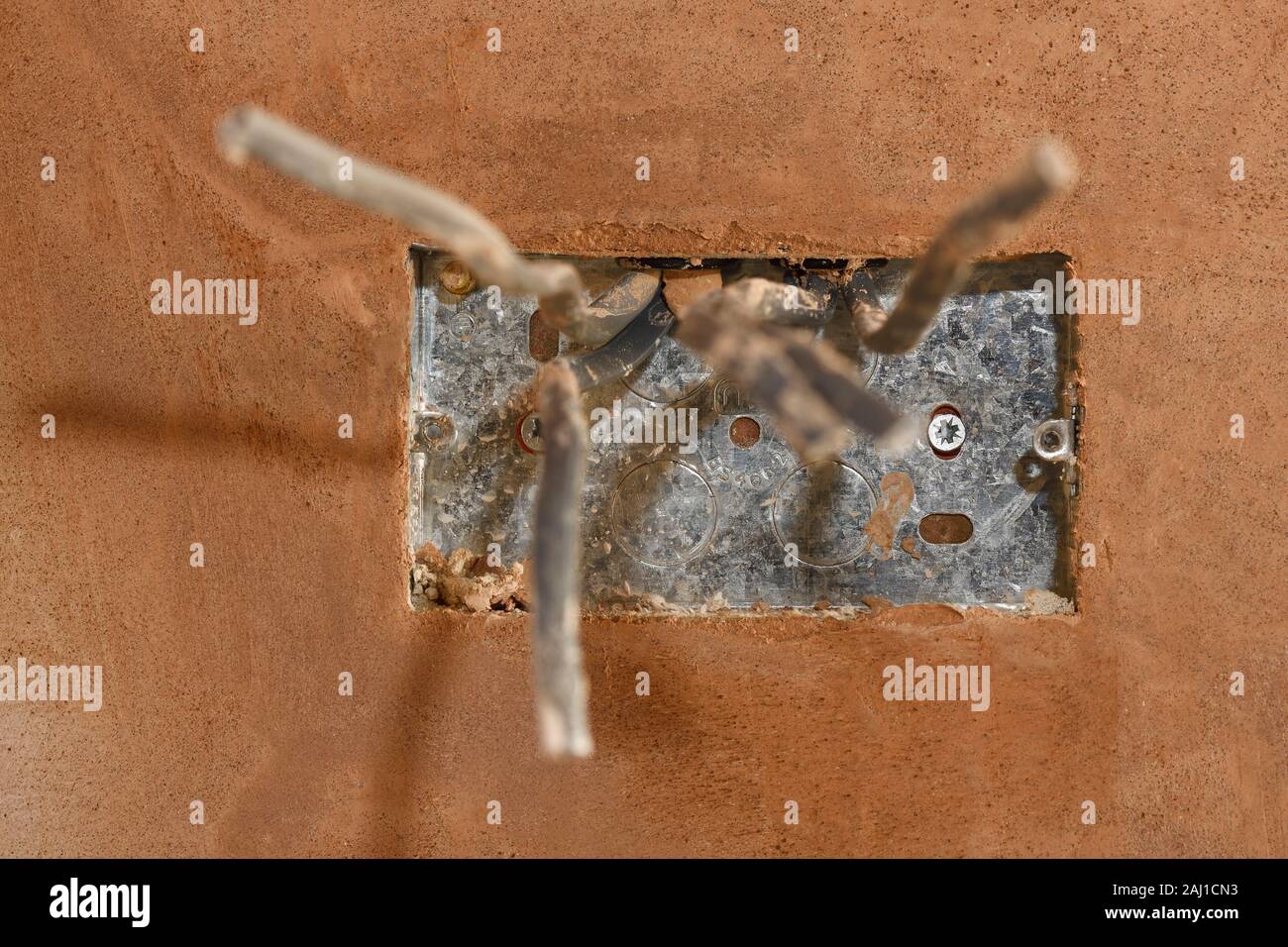 Einen ersten fix Steckdose in einem frisch Verputzte Wand Stockfoto