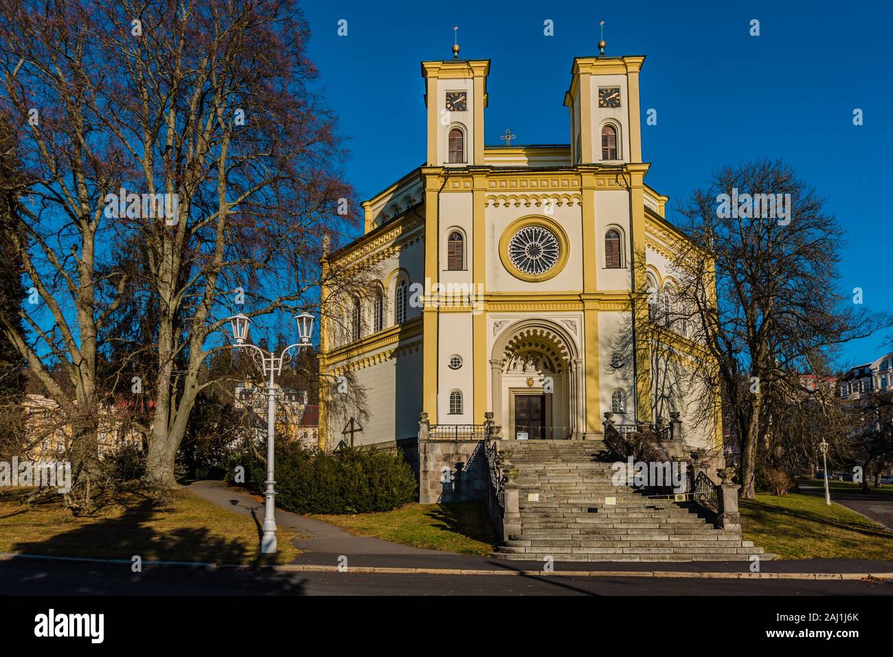 In Marianske Lazne, Tschechische Republik - 1. Januar 2020: Ansicht der Christlichen Kirche der Himmelfahrt der Jungfrau Maria mit zwei Türmen an einem sonnigen Wintertag. Stockfoto