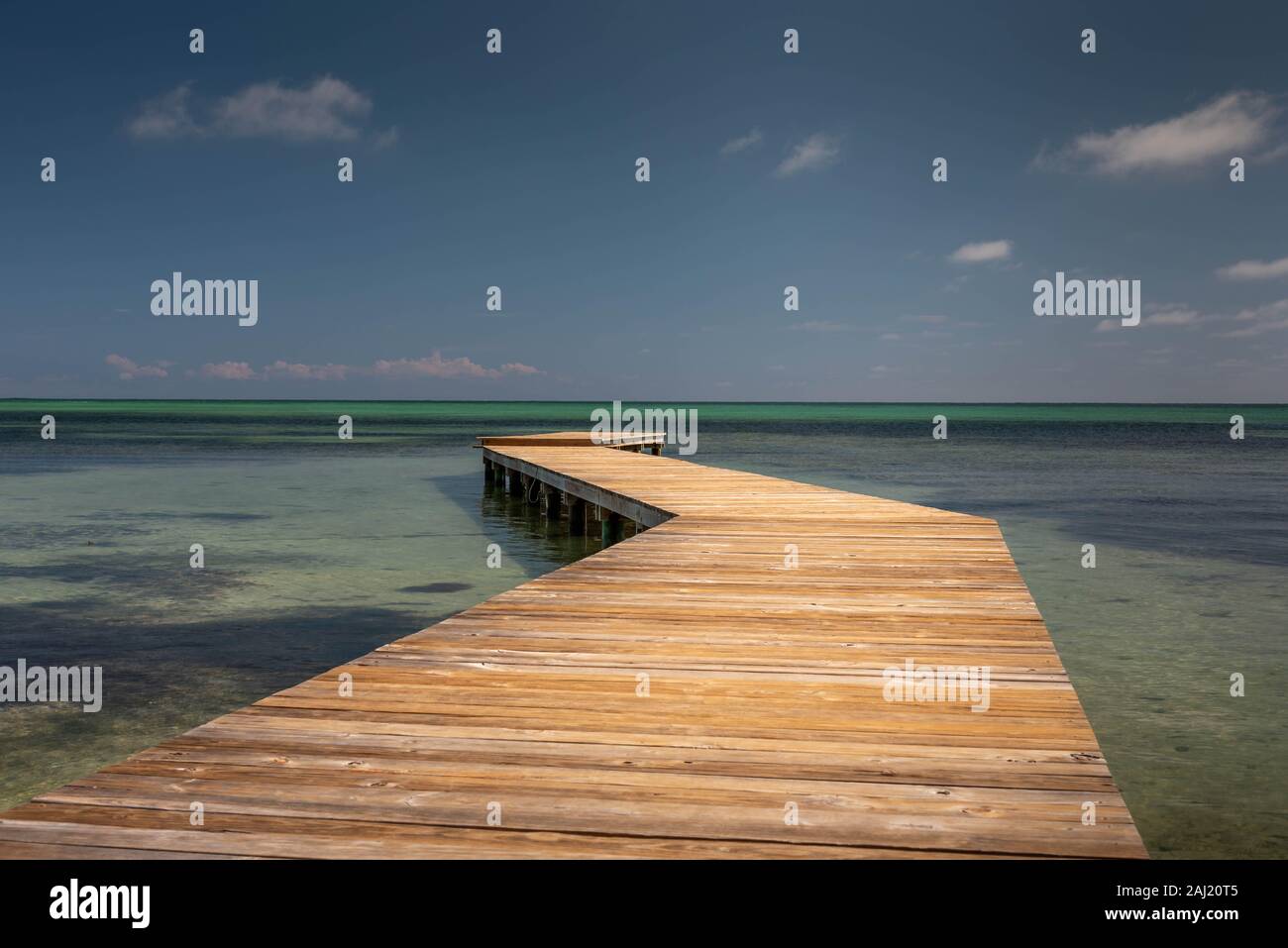 Ein Blick auf ein hölzernes Dock auf das türkisfarbene Meer in den Horizont führende platziert. Der leere Raum. Stockfoto