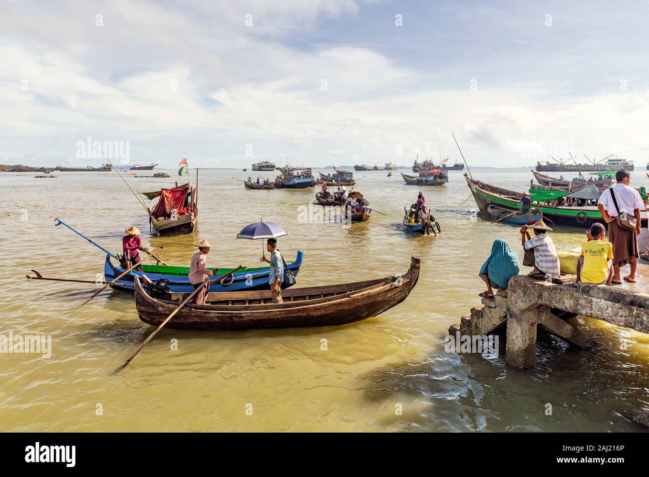 Sampans und andere kleine Boote in Sittwe Hafen, mit Menschen standen am Ufer, Rakhine, Myanmar (Birma), Asien Stockfoto