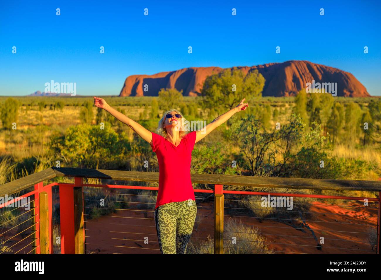 Touristische Frau genießen Uluru-Kata Tjuta Nationalpark, UNESCO-Heritge Ort, mit Uluru und Kata Tjuta im Hintergrund, Australien Stockfoto