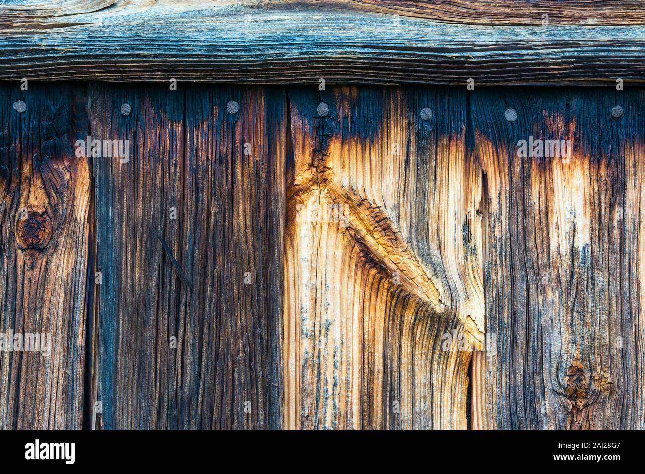 Alte rustikale Holzplanken. Detail der verblassten Holz Textur mit Knoten, die Nägel und die horizontalen Latten. Abstrakte vintage Hintergrund mit rauhe rissige Oberfläche. Stockfoto