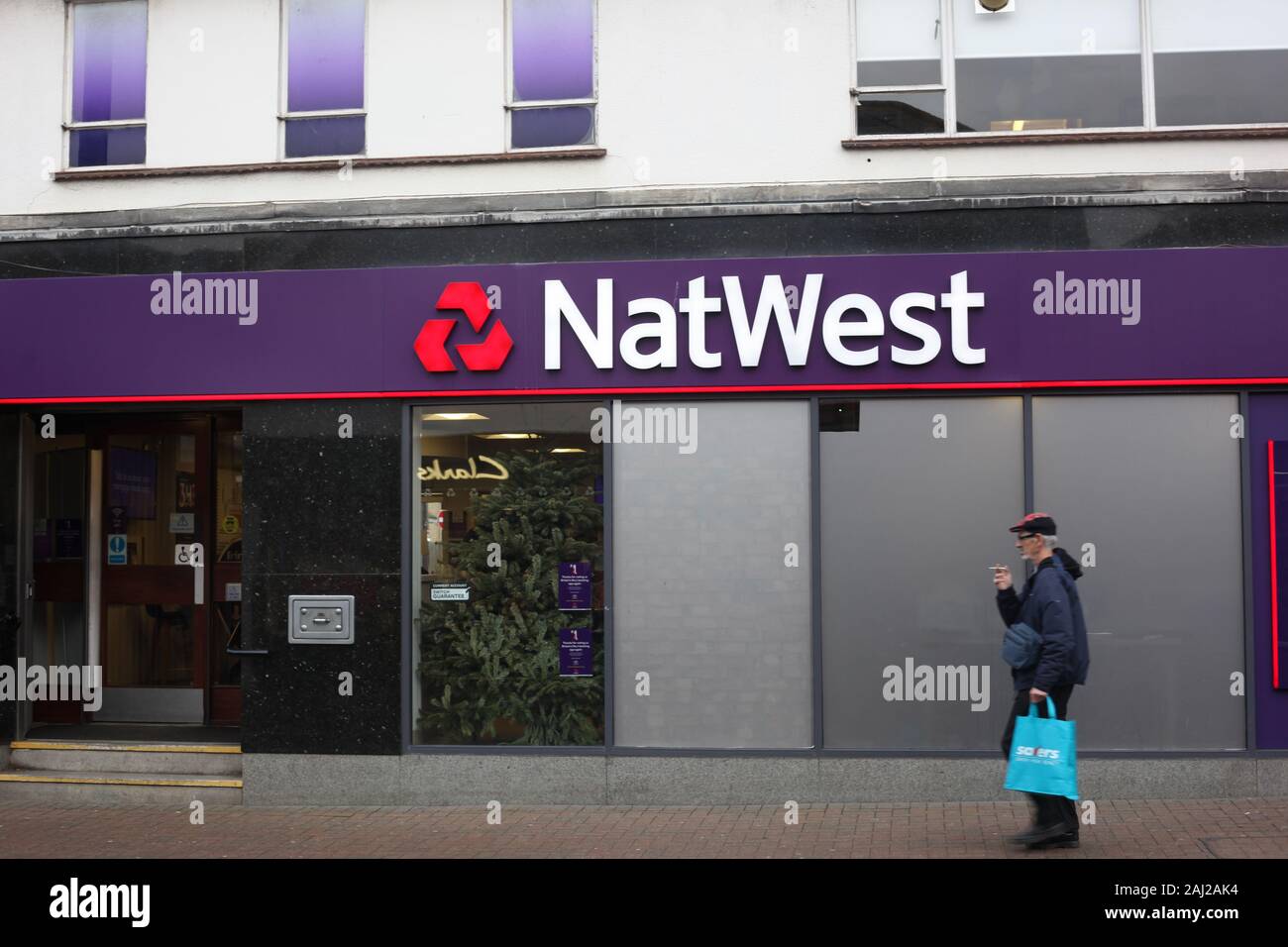 Ältere männliche vorbei gehen. ein Zweig der Nat West Bank im Wickford, Essex, Großbritannien. Stockfoto