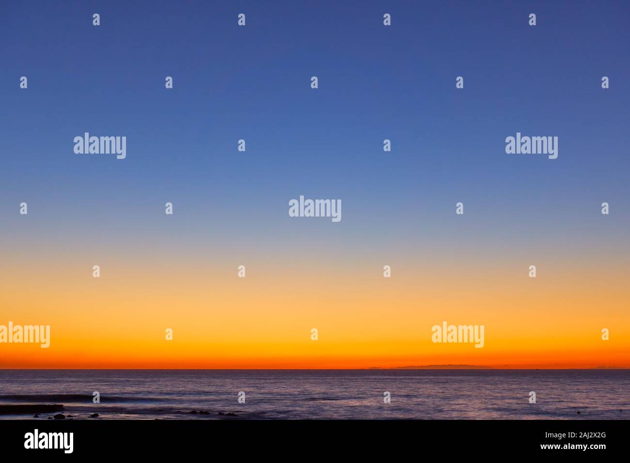 Orange Blau wolkenlosen Himmel über dem Meer bei Sonnenuntergang - Bunte natürliche Hintergrund und Raum für ihre eigenen Text Stockfoto