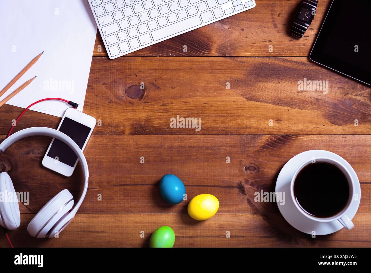 Business Schreibtisch mit Geräten und happy Ostern bunte Eier Hintergrund auf dekoriert braun Holztisch moderne Feder Dekoration workpla Stockfoto