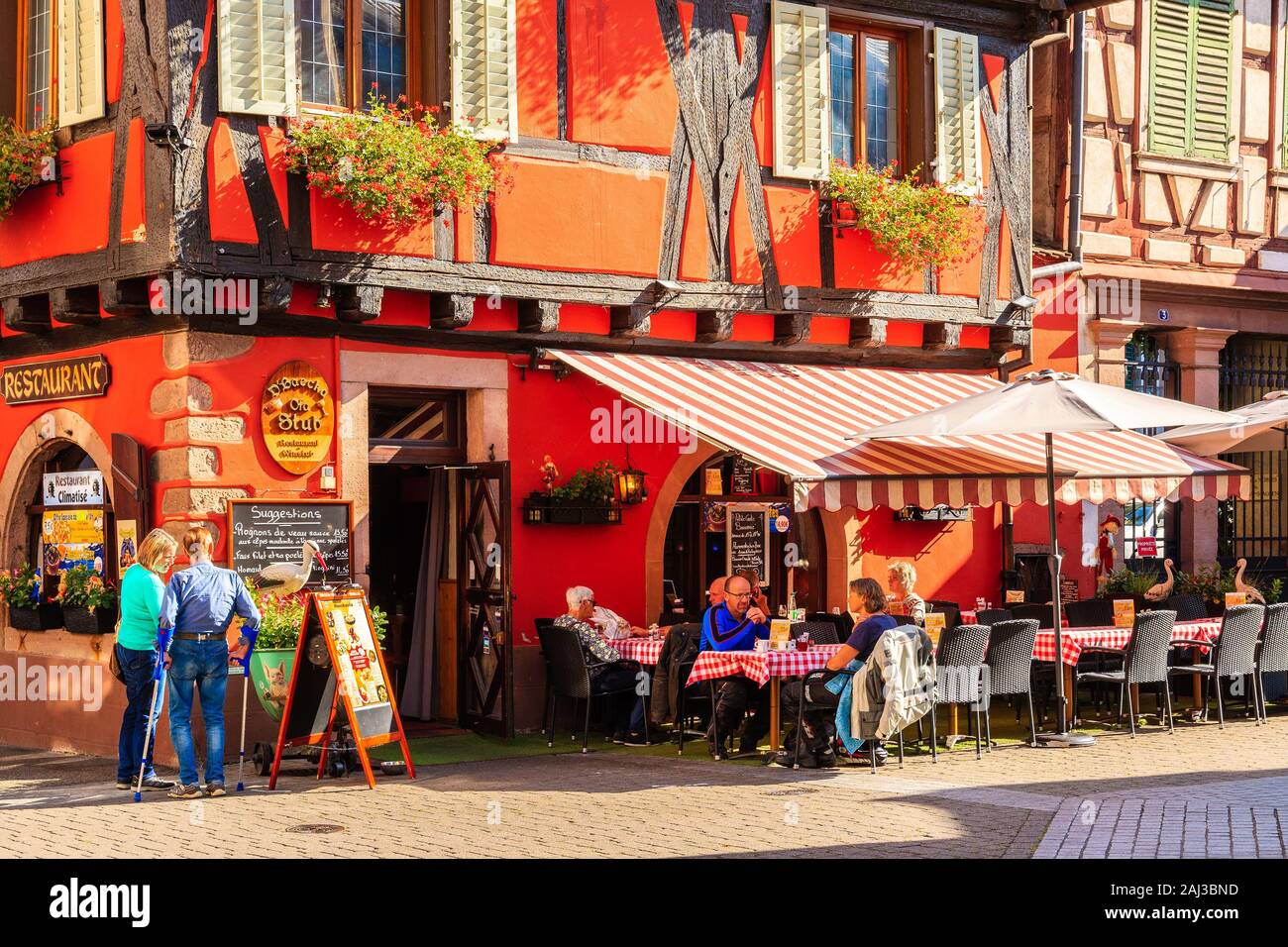 Elsass Wein Region, Frankreich - 20.SEPTEMBER, 2019: Die Menschen essen im Restaurant auf der Straße von Ribeauville Dorf, das auf der elsässischen Weinstraße, Franken befindet. Stockfoto