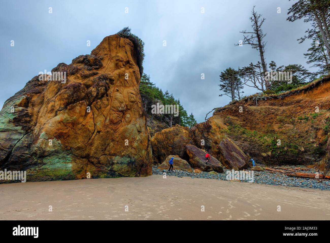 Drei junge Teens spielen auf Sandsteinfelsen auf Arcadia Beach, in der Nähe von Cannon Beach, Oregon. Stockfoto