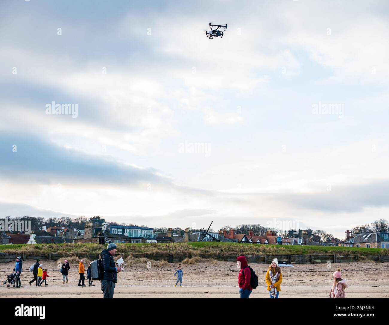 Ein Mann, der eine Drohne illegal in einer Menschenmenge am Strand, West Beach, North Berwick, East Lothian, Schottland, VEREINIGTES KÖNIGREICH Stockfoto