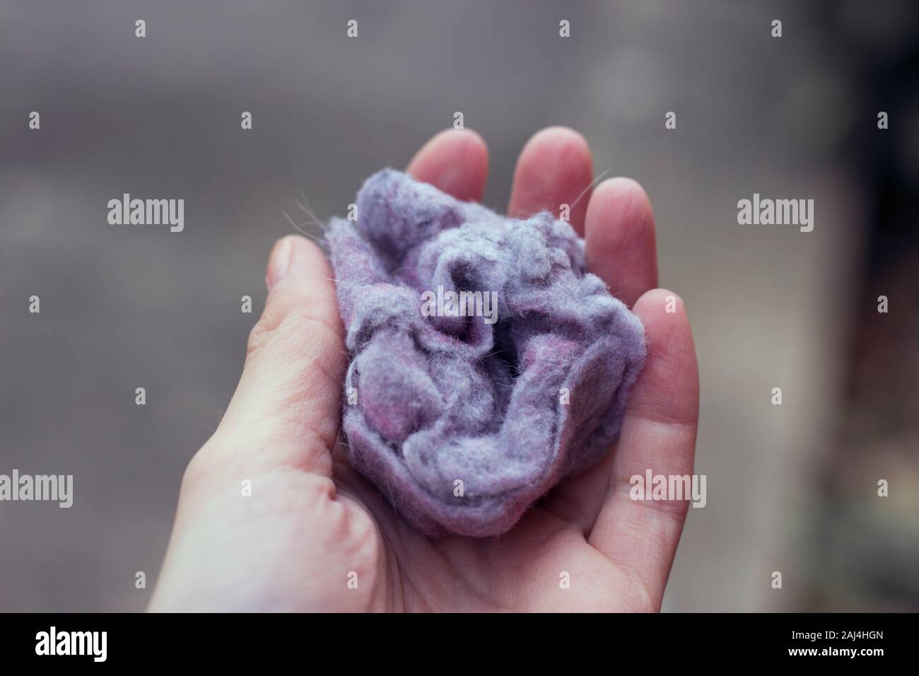 Flusen-/Flusenansammlungen auf Wäsche nach dem Entfernen von Kleidung Trockner auf weißem Hintergrund. Frau & Mann hand Stockfoto