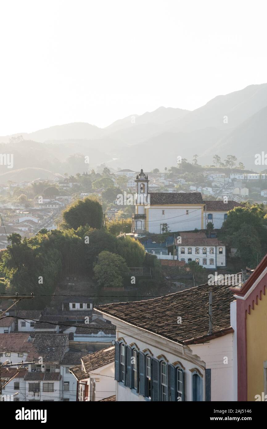 Blick über die Kolonialstadt Ouro Preto, Minas Gerais, Brasilien, mit einem weißen Kirche auf einem Hügel. Stockfoto