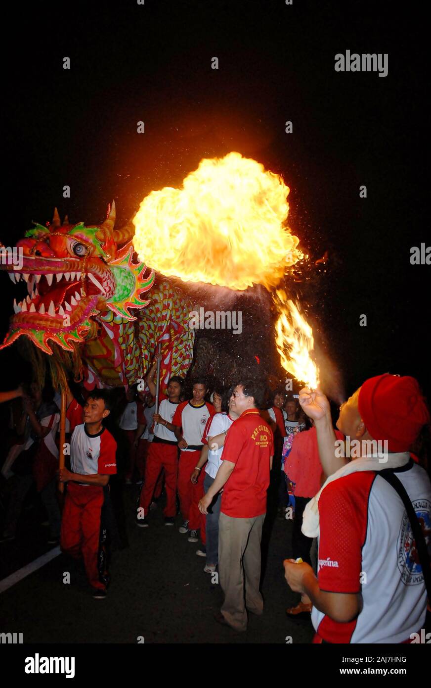 Ein Mann sprays Brand an einem Drachen Puppentheater in der chinesischen Neujahrsfest Festival. Stockfoto