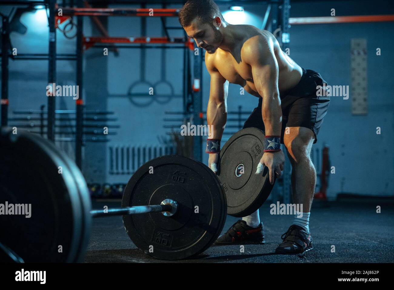 Kaukasischen Menschen üben im Gewichtheben in der Turnhalle. Kaukasier Männlich sportliche Modell der Vorbereitung für Training, schaut zuversichtlich und stark. Body Building, gesunden Lebensstil, Bewegung, Aktivität, action concept. Stockfoto