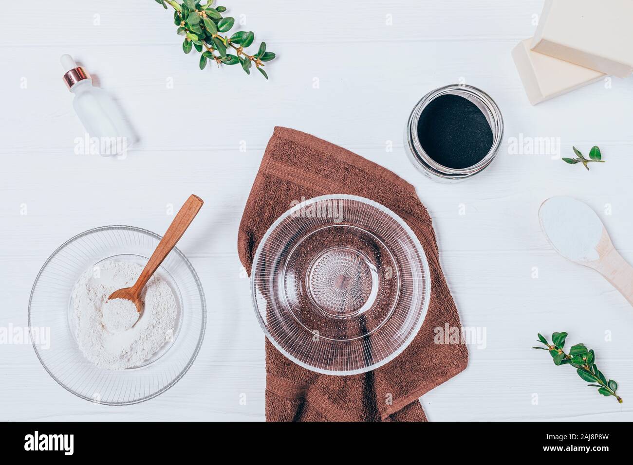 Ansicht von oben leere Glas Schüssel neben Zutaten für die Herstellung von hausgemachten Clay Mask auf weissem Holztisch Stockfoto