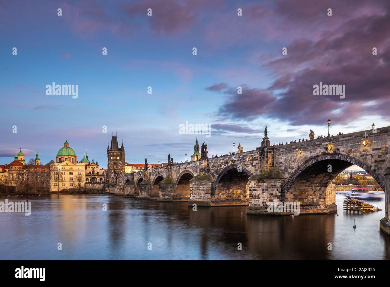 Prag, Tschechische Republik - Schöne lila Sonnenuntergang und Himmel bei der weltberühmten Karlsbrücke (Karluv most) und St. Franz von Assisi Kirche auf einem Winter Stockfoto
