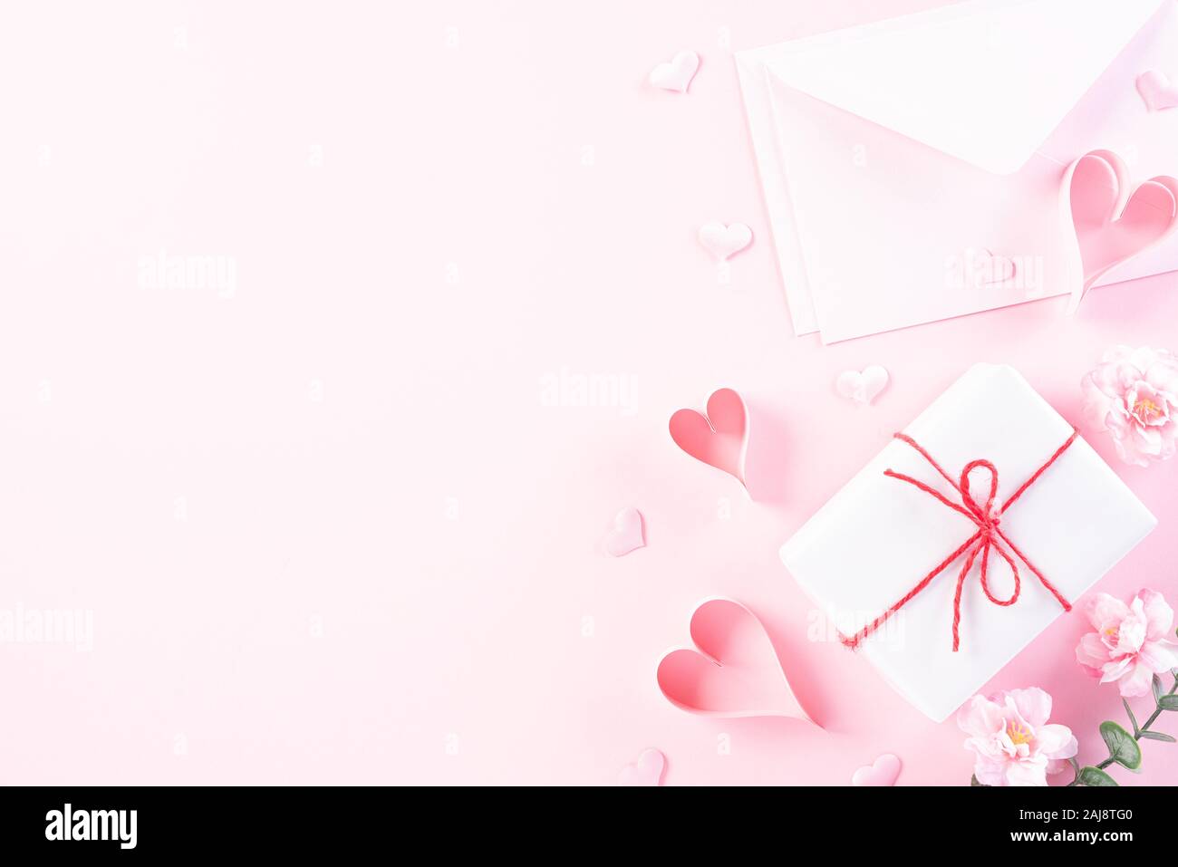 Rosa Papier Herzen mit Anschreiben und Geschenkbox auf Rosa pastell Papier Hintergrund. Liebe und Valentinstag Konzept. Stockfoto