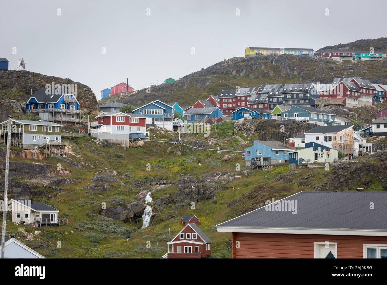 Bunte Holzhäuser eingebettet am Hang in Qaqortoq, die bevölkerungsreichste Stadt im südlichen Grönland. Stockfoto