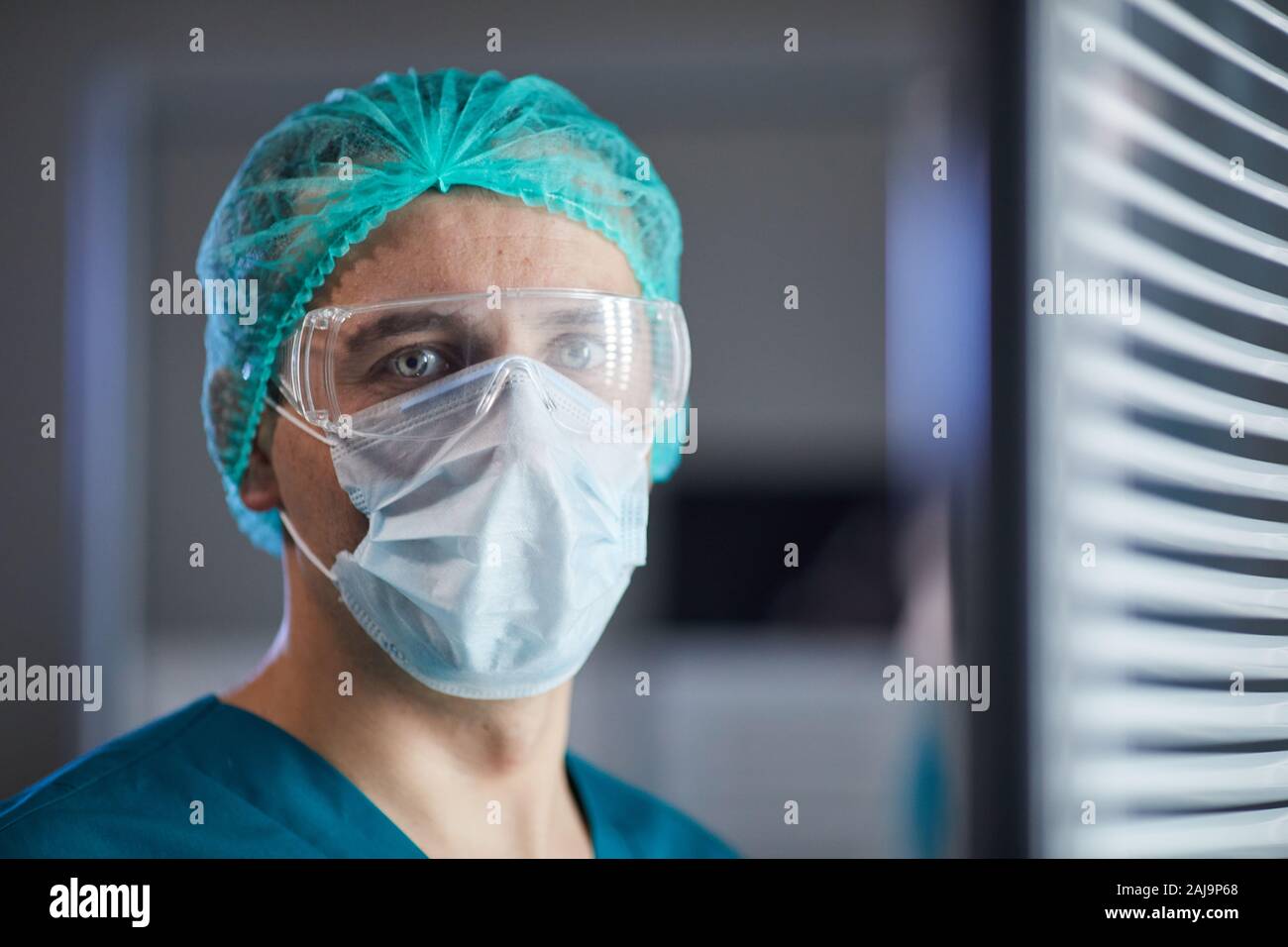 Männliche reife Chirurgen durch das Tragen von schützender Maske und Brille für den Betrieb am Krankenhaus bereit Stockfoto