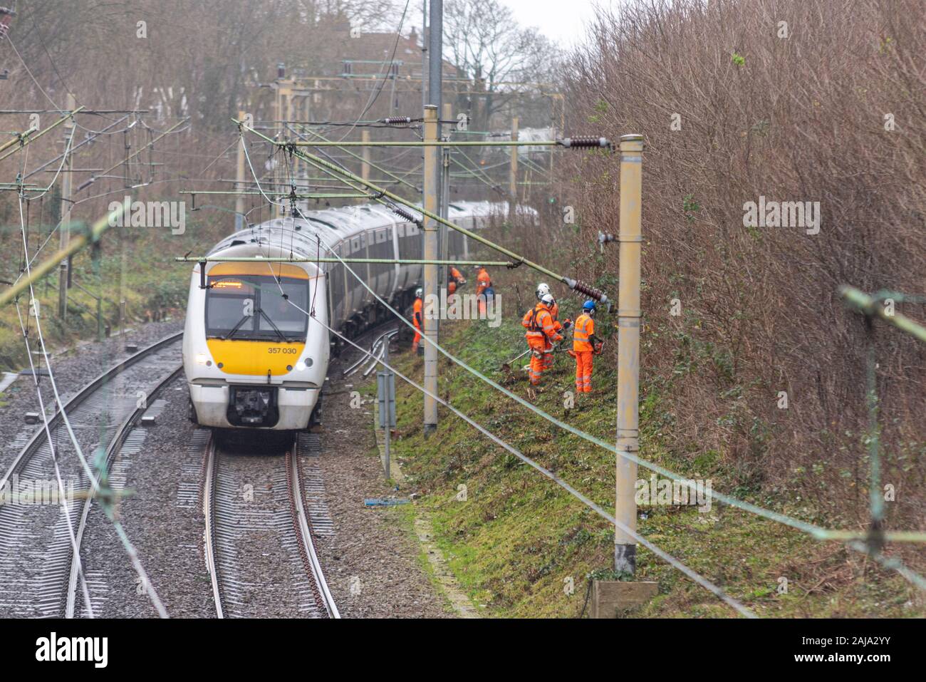 RailScape Arbeitnehmer zurück schneiden Vegetation in der Nähe der Spur des C2C-Eisenbahn in Southend On Sea, Essex, Großbritannien. Dauerhafte weise Crew mit Zug passiert Stockfoto