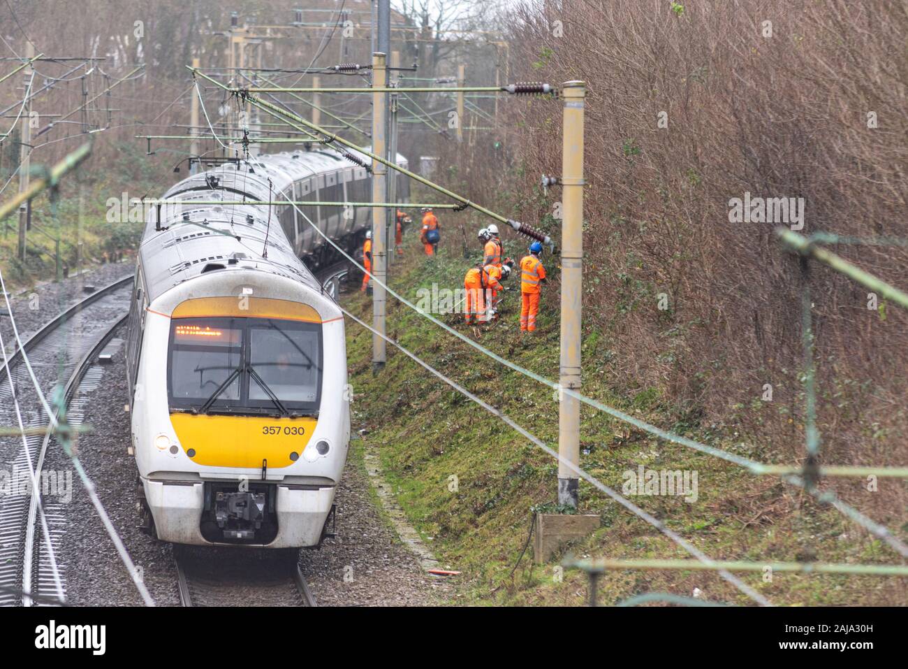 RailScape Arbeitnehmer zurück schneiden Vegetation in der Nähe der Spur des C2C-Eisenbahn in Southend On Sea, Essex, Großbritannien. Dauerhafte weise Crew mit Zug passiert Stockfoto