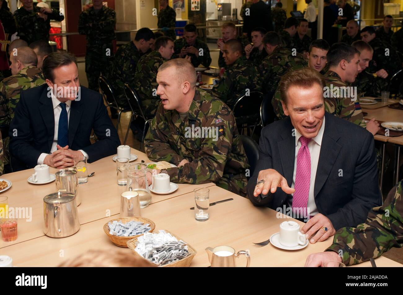 Der kalifornische Gouverneur Arnold Schwarzenegger und Premierminister David Cameron mit britischen Truppen aus dem 1 Bataillon den Grenadier Guards am Wellington Barracks in London. Stockfoto