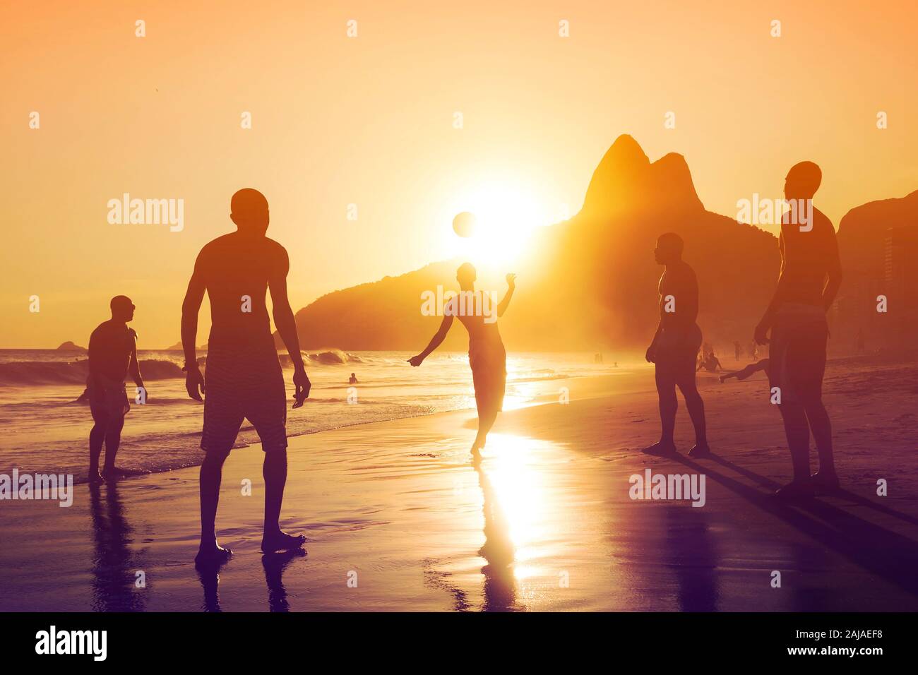 Silhouette der nicht identifizierten, unkenntlich einheimischen Ball spielen Spiel bei Sonnenuntergang an den Strand von Ipanema, Rio de Janeiro, Brasilien. Stockfoto