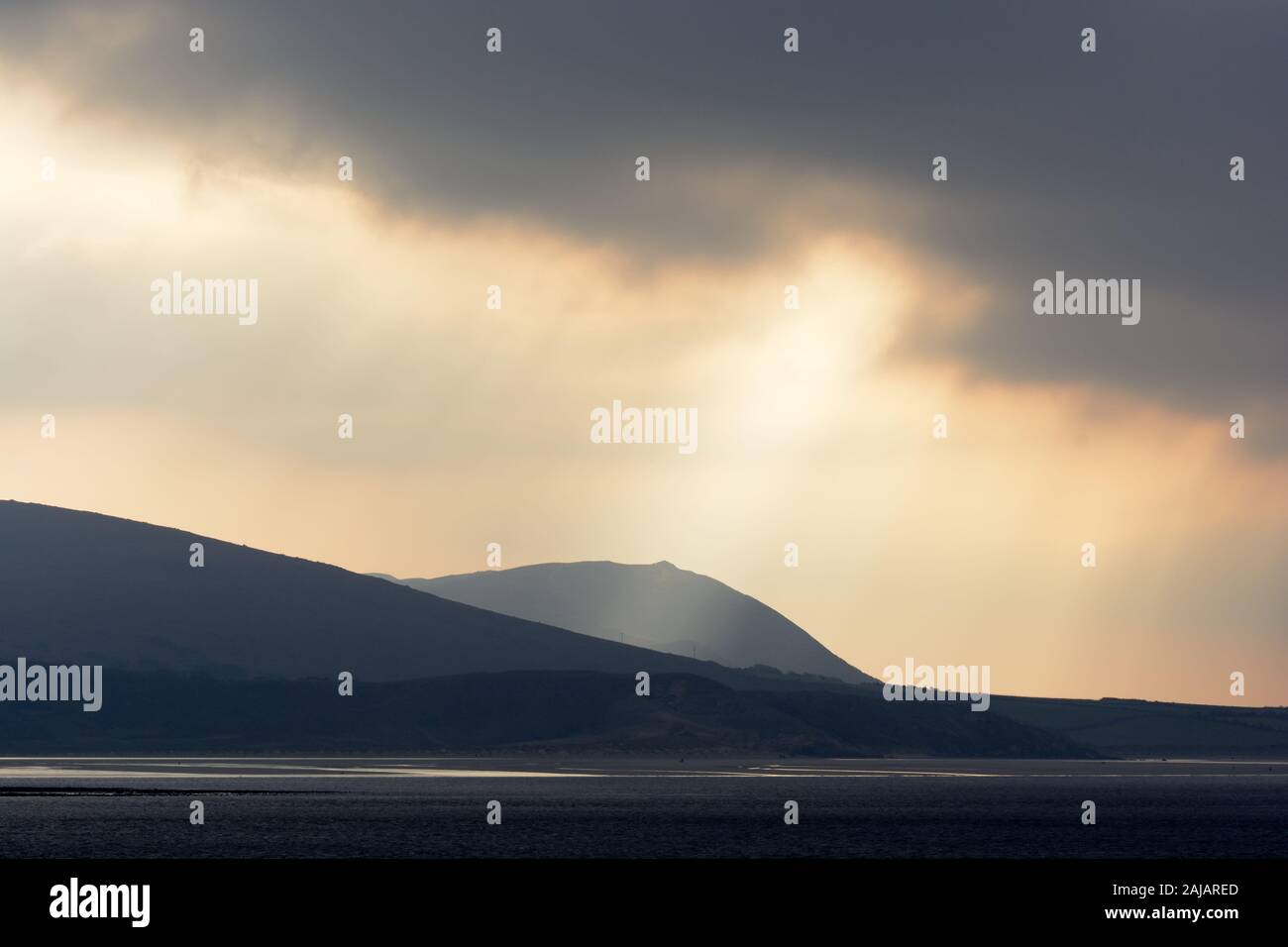 Dramatische stürmischen Sonnenuntergang und Wellen von Licht über der Halbinsel Gower Wales Cymru GROSSBRITANNIEN Stockfoto