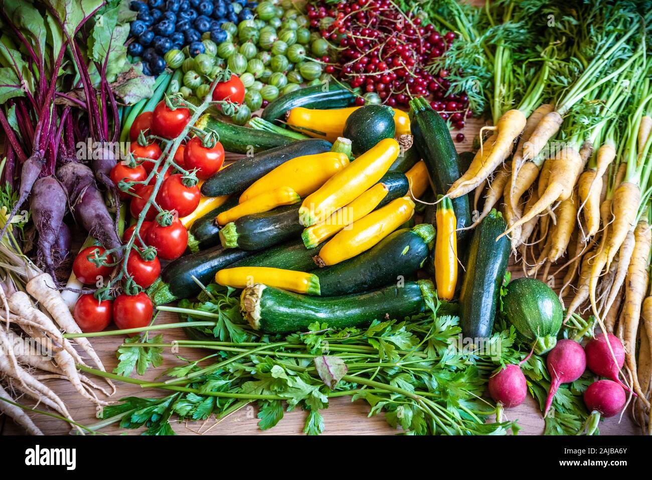 Frisches Gemüse auf einem Tisch wie Zucchini, Tomaten, Petersilie Wurzeln Stockfoto