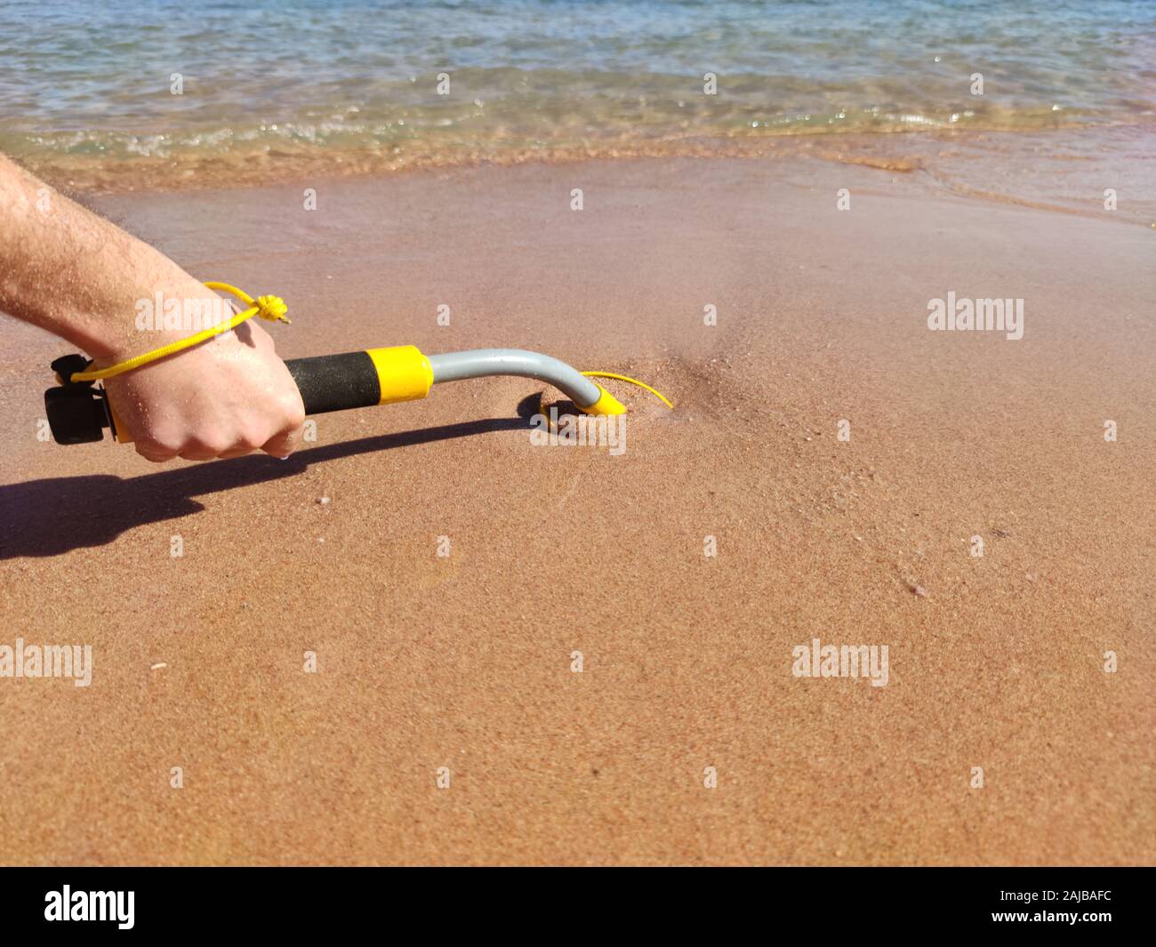 Das Foto von einem Unterwasser Metalldetektor Vel auf dem Sand. Schatz suchen und touristische Abenteuer Hintergrund. Stockfoto