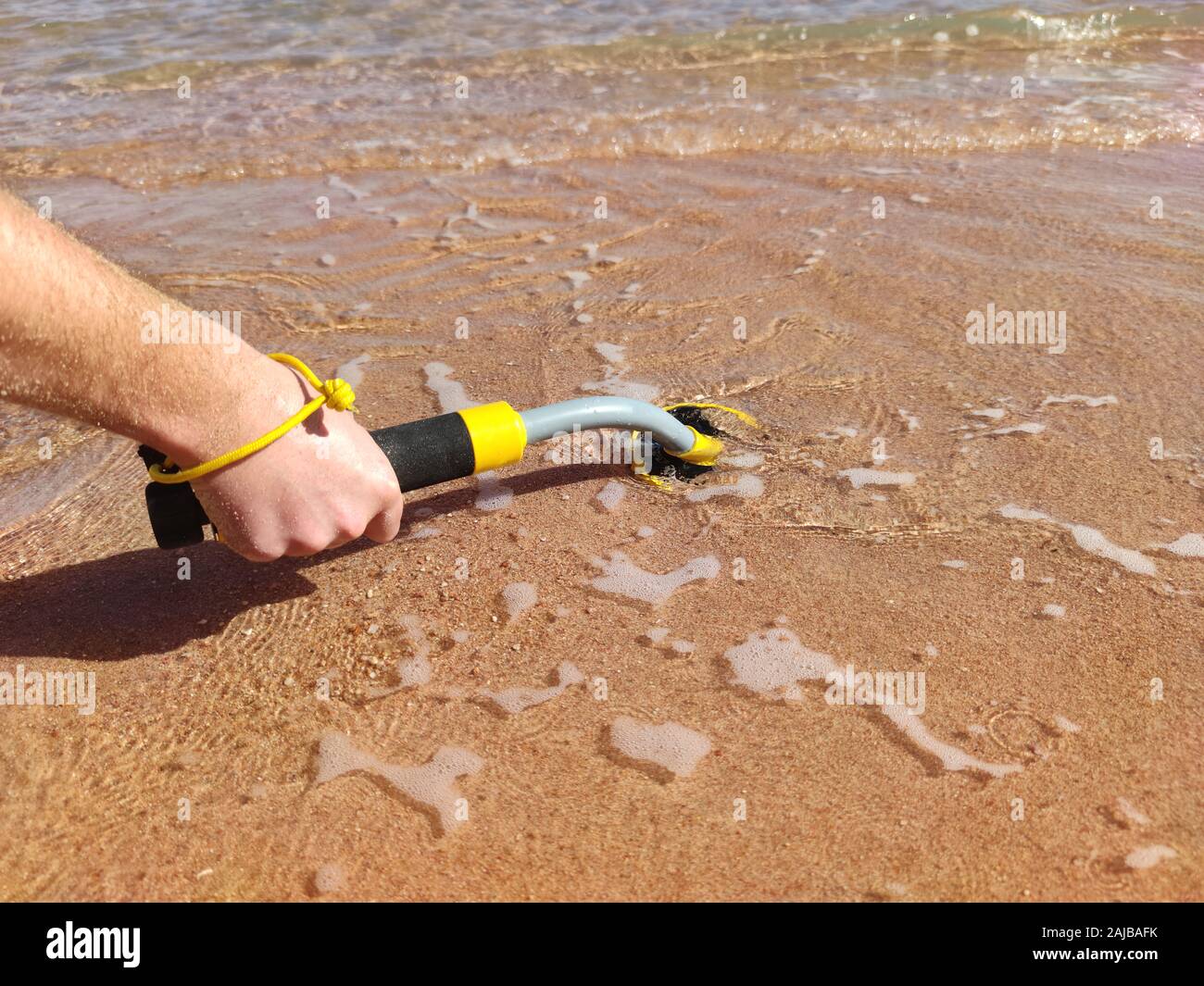 Das Foto von einem Unterwasser Metalldetektor Vel auf dem Sand. Schatz suchen und touristische Abenteuer Hintergrund. Stockfoto