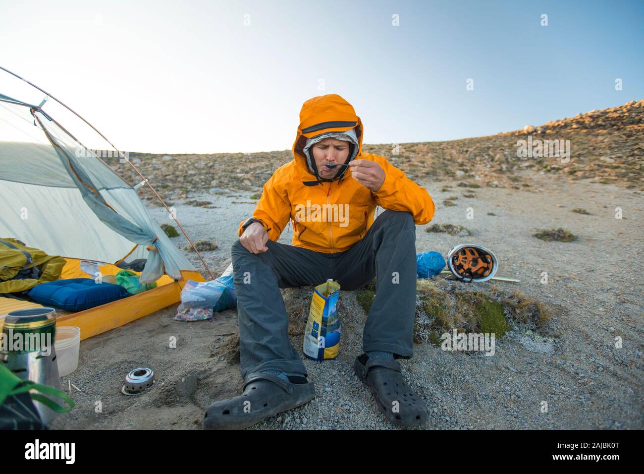 Wanderer genießt ein Essen neben seinem Zelt. Stockfoto