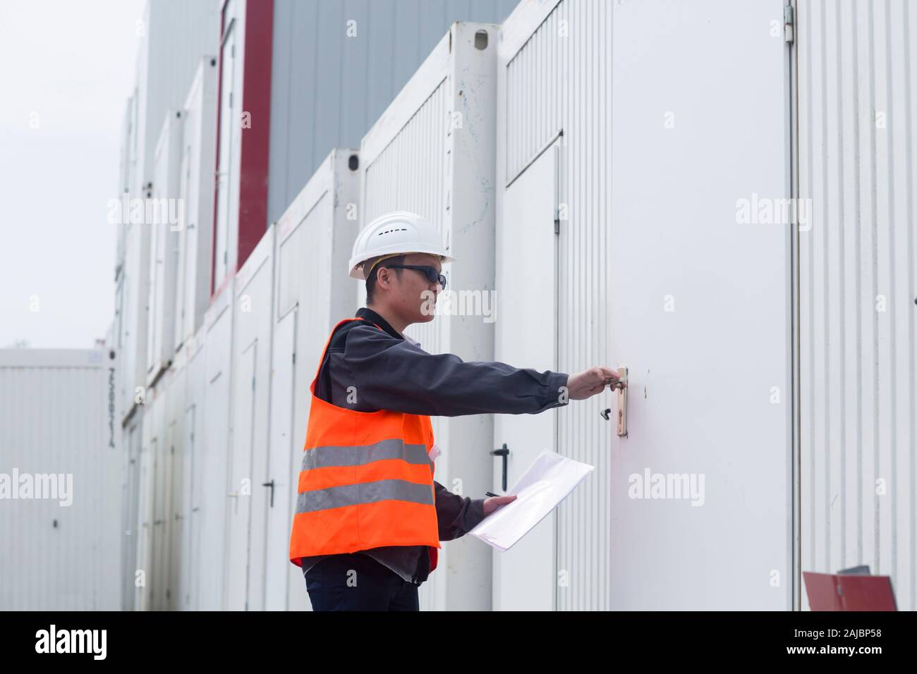 Arbeiter außerhalb, der ein Containerbüro eröffnet Stockfoto