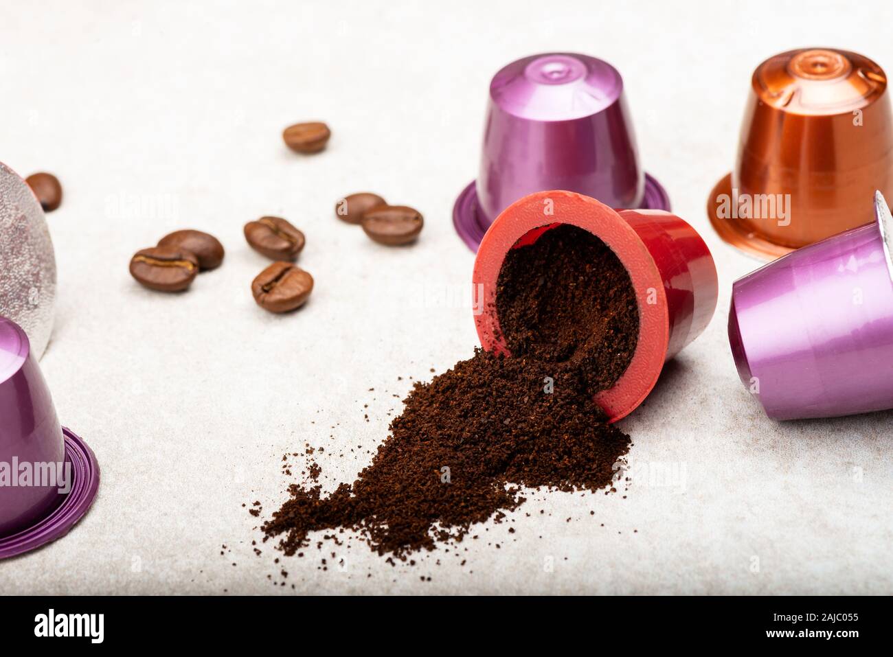 Öffnen Espresso Kaffee Kapseln oder Hülsen und Kaffeebohnen auf grauem Hintergrund, Ansicht von oben Stockfoto