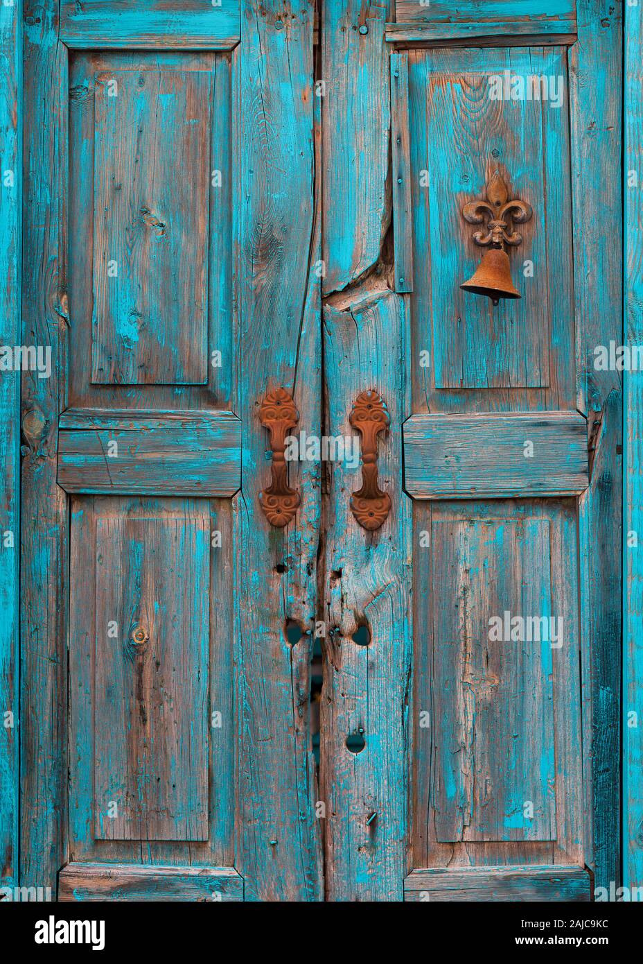 Zersplitterte Holz- türkis Tür mit abblätternder Farbe und rostige Bell in der Altstadt von Mesilla, New Jersey in der Nähe von Las Cruces Stockfoto