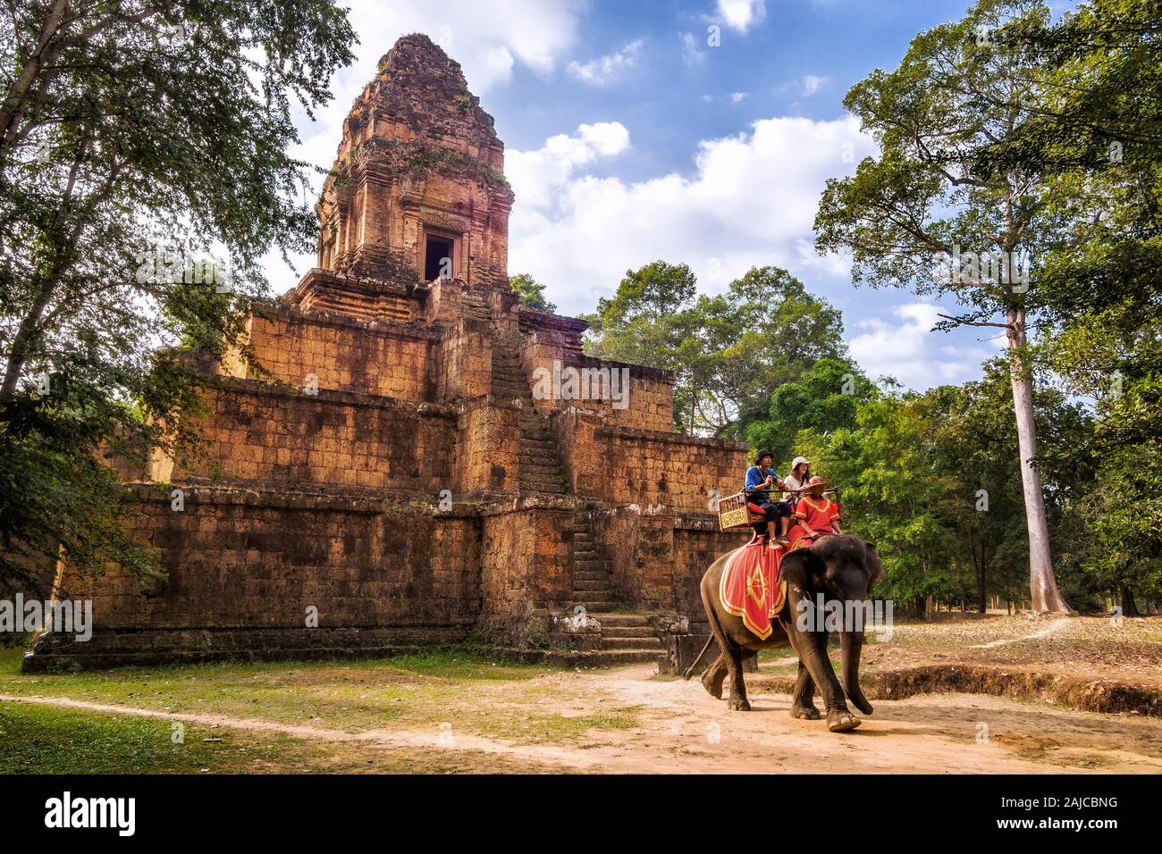 Touristen reiten Elefanten vor der alten Khmer Tempel Ruinen von Angkor, Siem Reap, Kambodscha. Stockfoto
