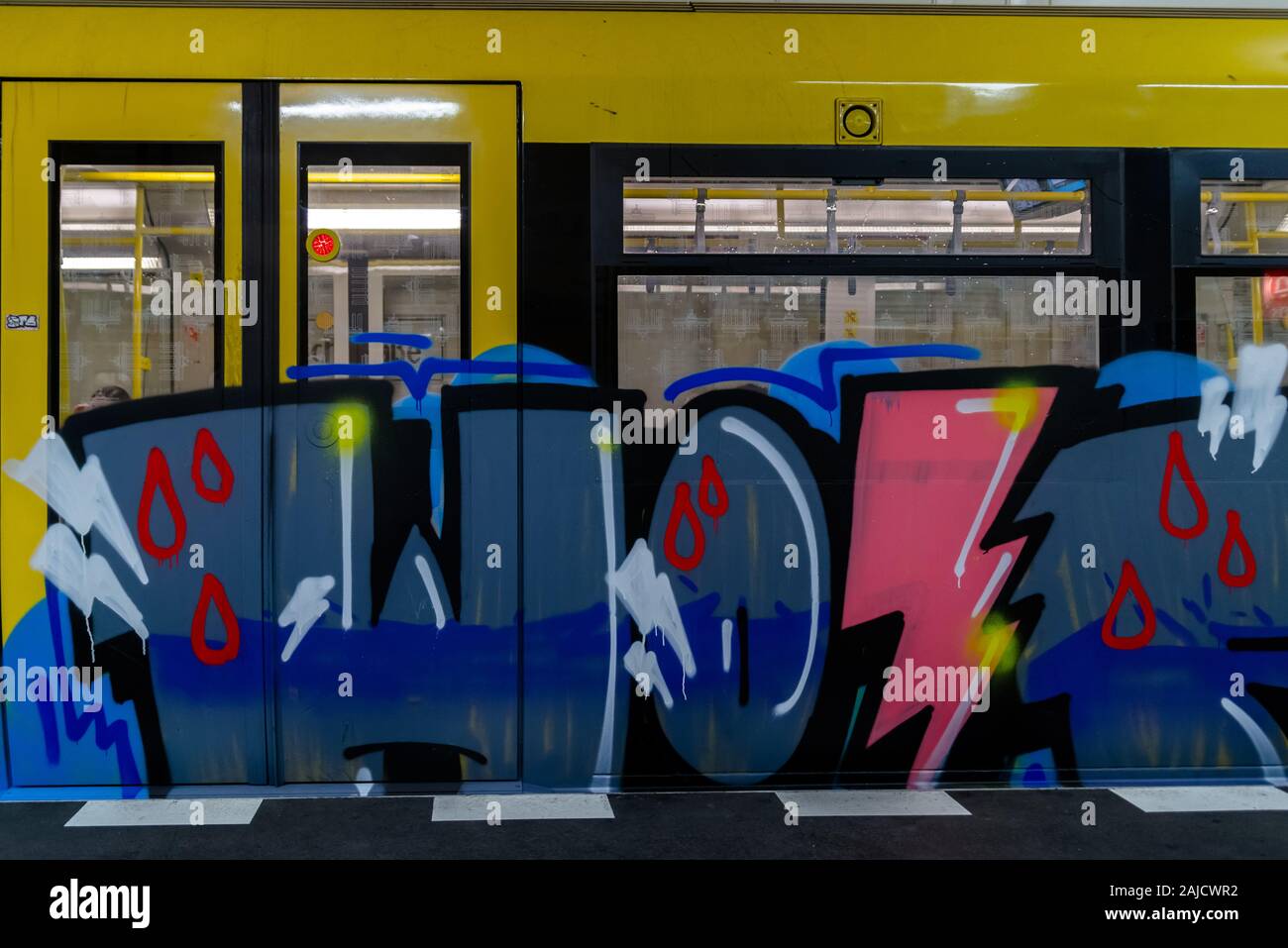 Street Art. Abstraktes Hintergrundbild eines vollendeten Graffiti-Gemäldes in beige- und orangenen Tönen mit der U-Bahn. Februar 19, 2019. Berlin Stockfoto