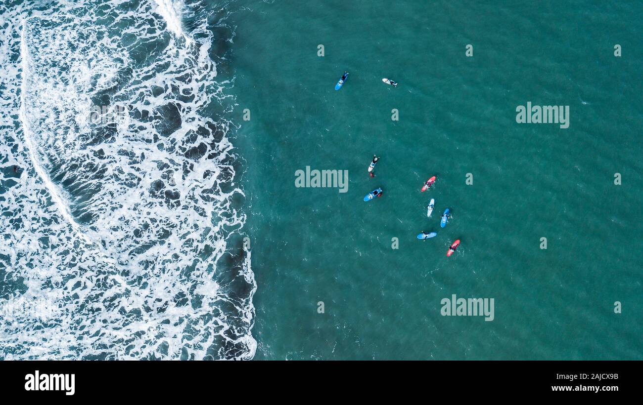 Luftaufnahme von surfer Schwimmen an Bord in der Nähe von riesigen Blue Ocean Wave in Porto da Cruz, Madeira, Portugal Stockfoto