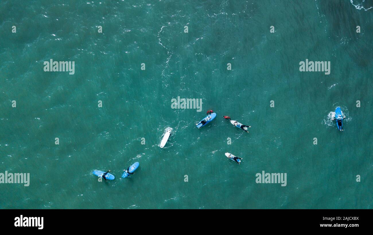 Luftaufnahme von surfer Schwimmen an Bord in der Nähe von riesigen Blue Ocean Wave in Porto da Cruz, Madeira, Portugal Stockfoto