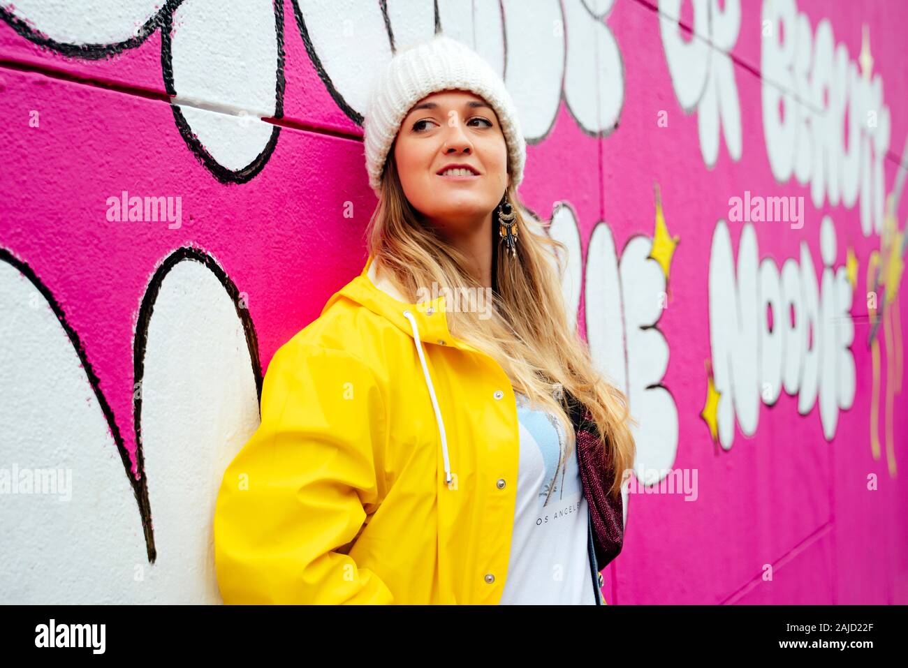 Attraktive blonde Frau auf einem rosa Wand posieren Stockfoto