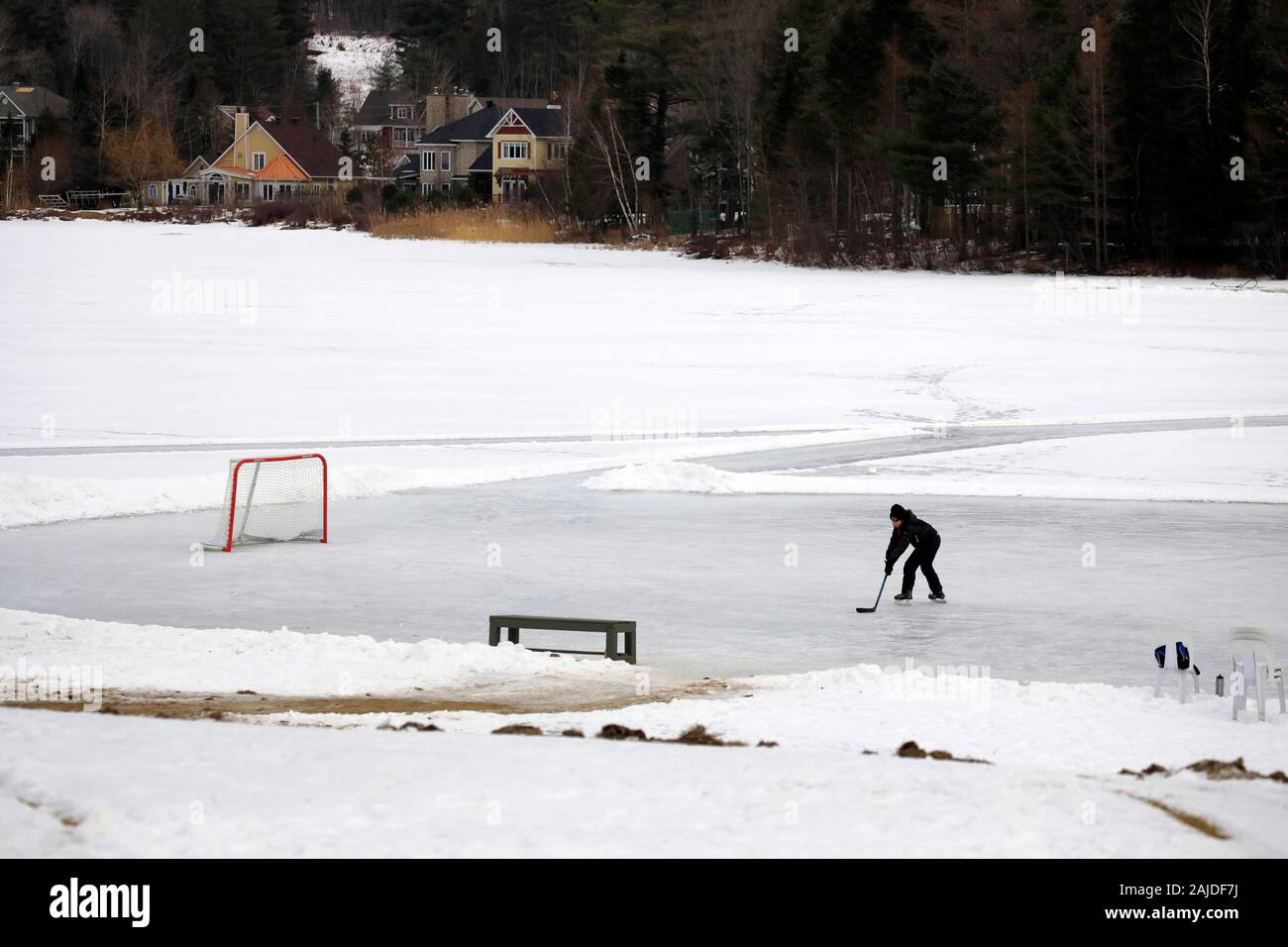 Ein Eishockeyspieler üben allein auf einem gefrorenen See.Mont Orford National Park.Orford.Eastern Townships.Quebec.Kanada Stockfoto