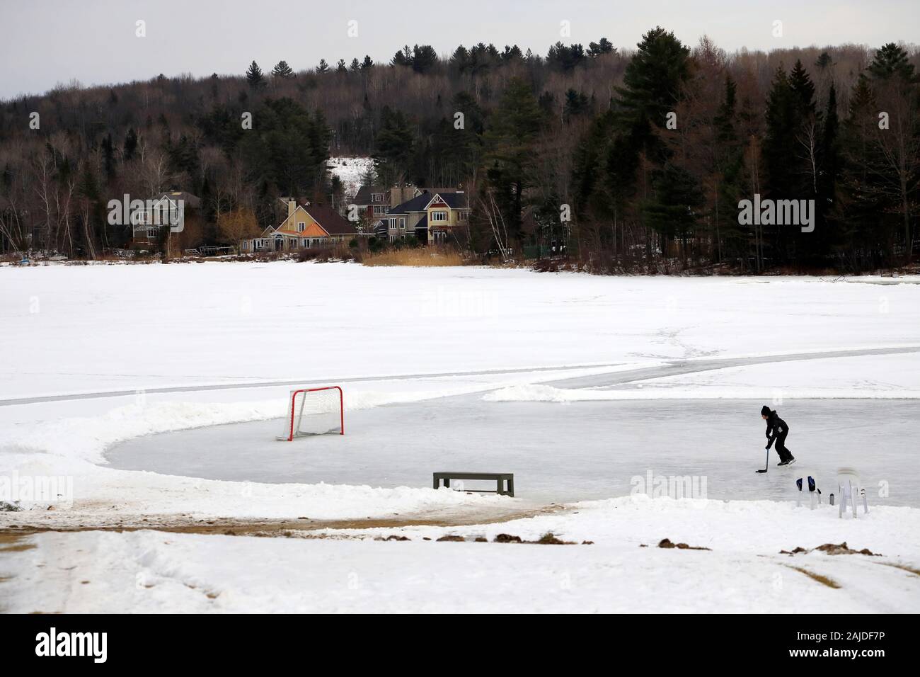 Ein Eishockeyspieler üben allein auf einem gefrorenen See.Mont Orford National Park.Orford.Eastern Townships.Quebec.Kanada Stockfoto