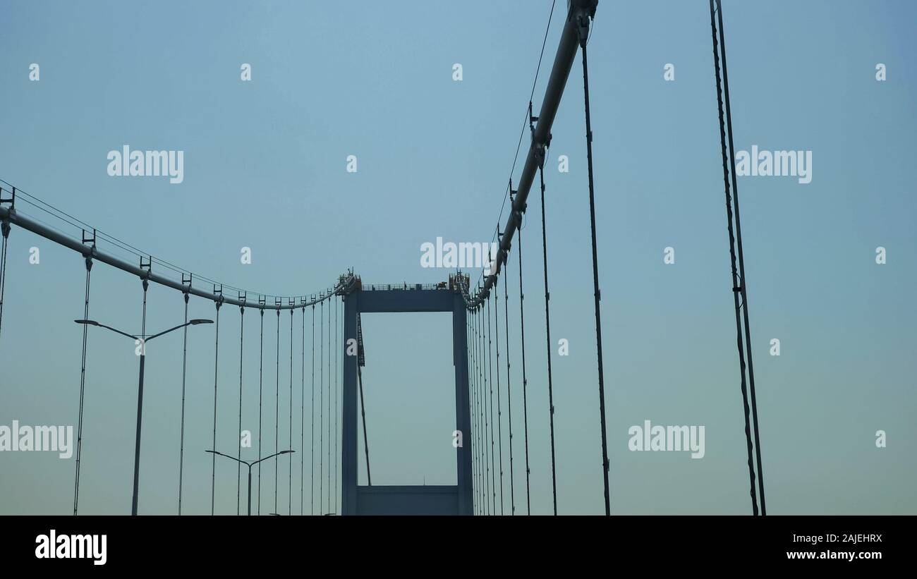 Bewegung Vergangenheit Straßenbeleuchtung entlang der oberen Teil des Selbst verankerte hängebrücke gegen Grenzenlose blauer Himmel Stockfoto