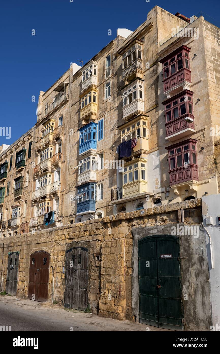 Traditionelle Häuser aus Stein mit maltesischen Stil mit Balkonen in Stadt Valletta in Malta, autogaragen an der Unterseite. Stockfoto