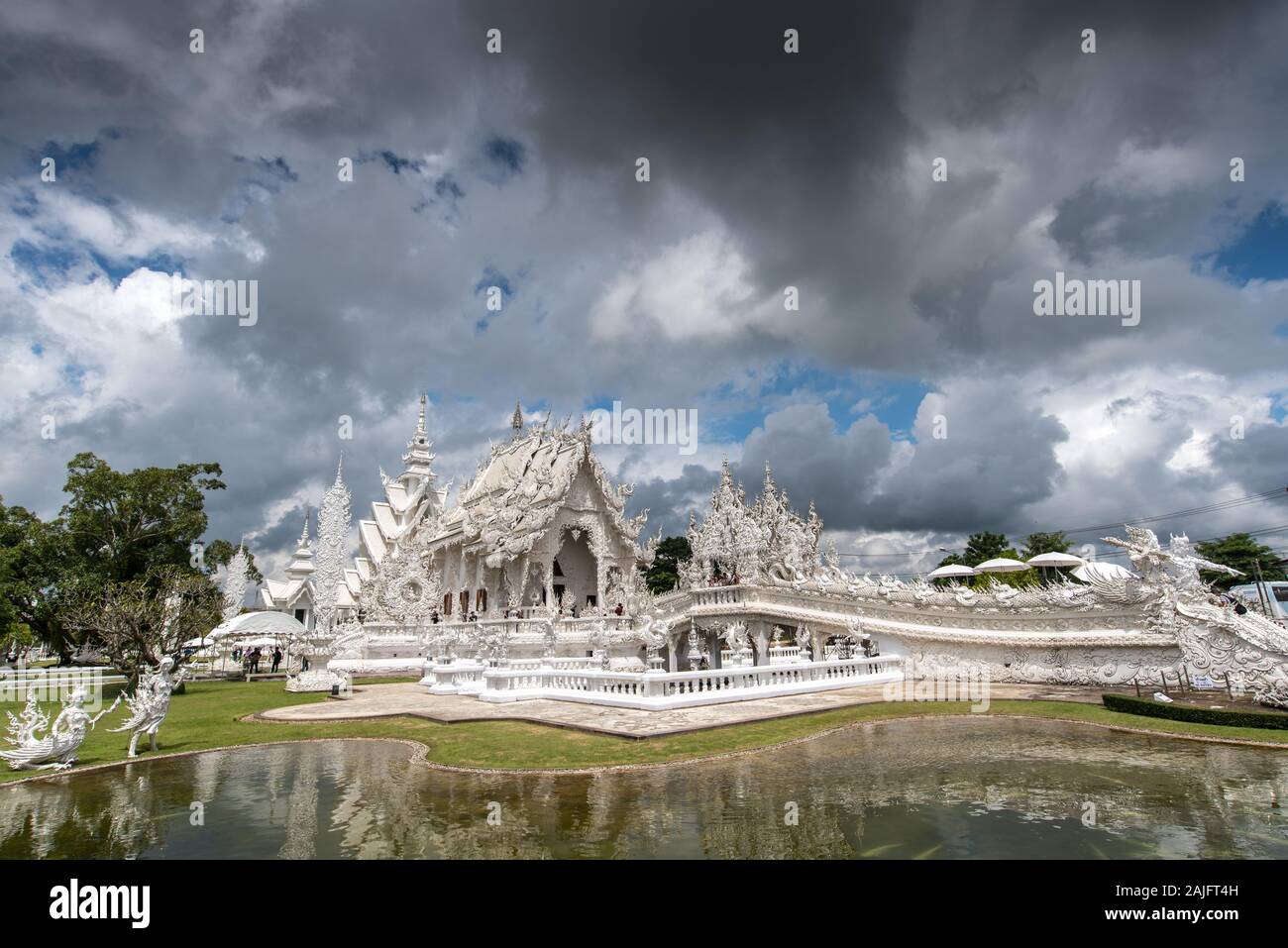 Chiang Rai, Thailand: Wat Rong Khun, weiße Tempel, gegen eine dramatische Wolkenhimmel. Dieses moderne Gebäude ist eines der wichtigsten thailändischen Attraktionen Stockfoto