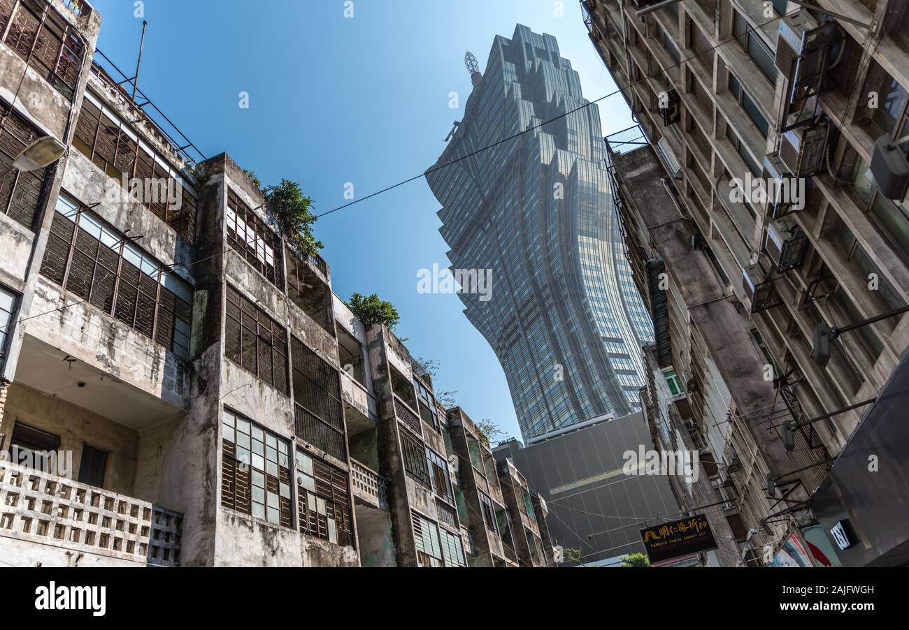 Macau, China: Der Grand Lisboa Casino Wolkenkratzer, Kontrast zwischen alten und neuen Gebäuden mit verfallenen Fassaden Stockfoto