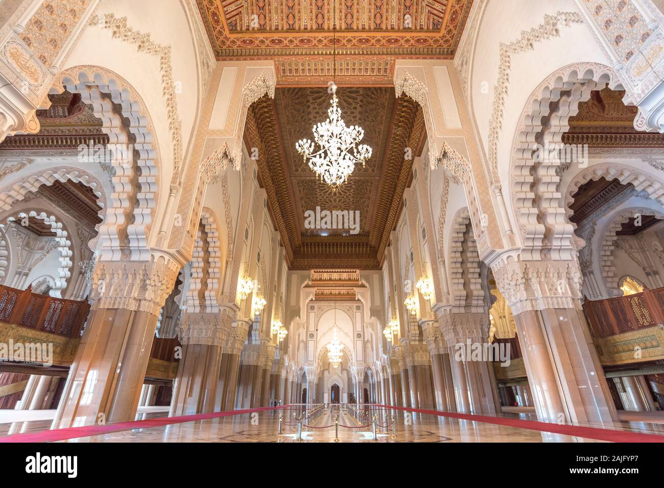 Casablanca, Marokko: Innenraum (gebetsraum) der Hassan II Moschee mit Säulen, Bögen und Kronleuchtern aus Murano-Glas. Islamische Architektur Stockfoto