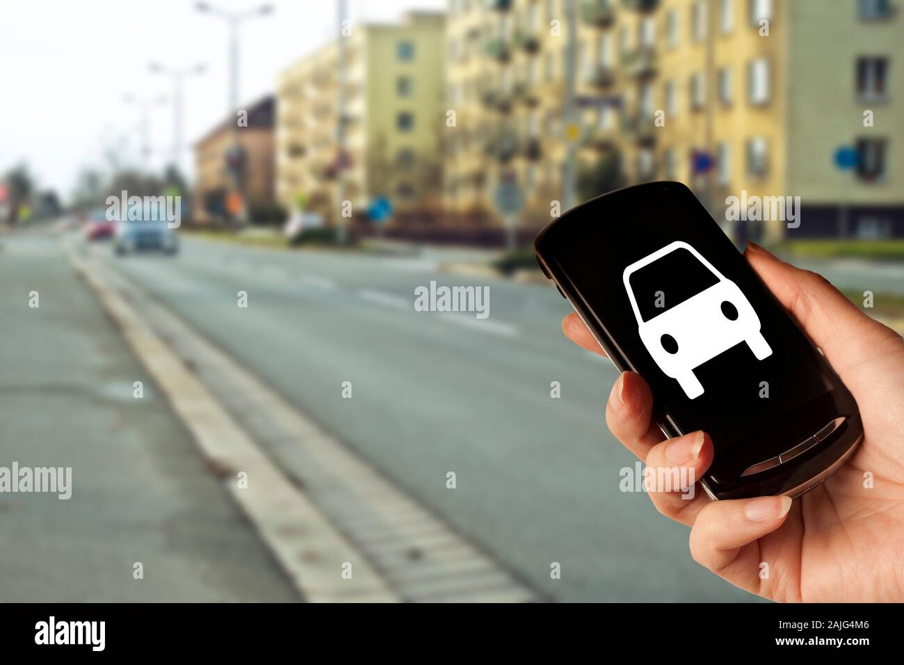 Hand, die ein Smartphone mit einer Auto-Symbol, Konzept für Car Sharing, App für Taxi oder Uber, Auto Apps Stockfoto