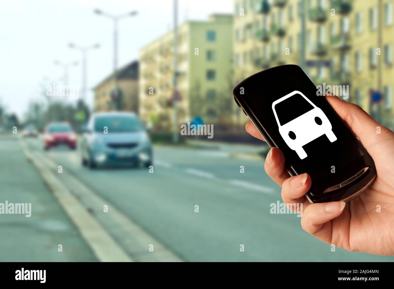 Hand, die ein Smartphone mit einer Auto-Symbol, Konzept für Car Sharing, App für Taxi oder Uber, Auto Apps Stockfoto