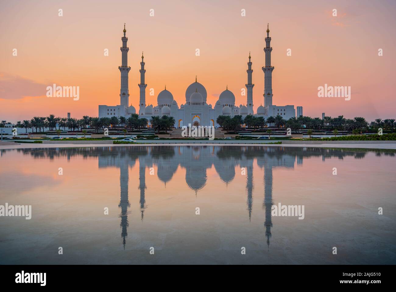 Abu Dhabi, VAE, Vereinigte Arabische Emirate: Abu Dhabi, Sheikh Zayed Moschee (auch bekannt als Grand Mosque) in der Dämmerung, der Reflexion im Wasser, bei Sonnenuntergang Stockfoto