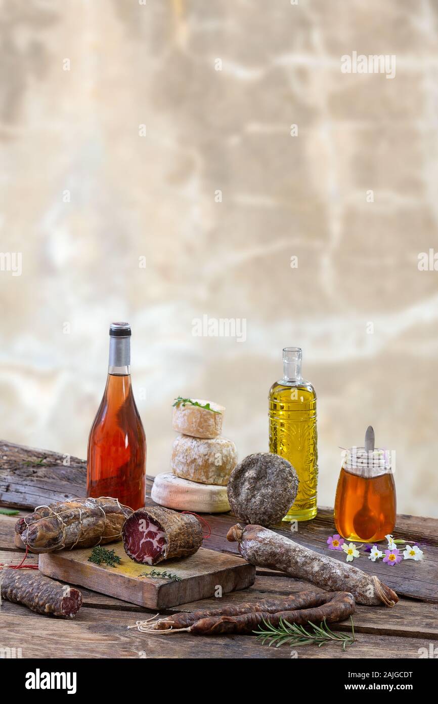 Mehrere traditionelle korsische Wurst mit einem Olivenzweig und schwarzen Oliven auf Holz- Hintergrund. Stockfoto