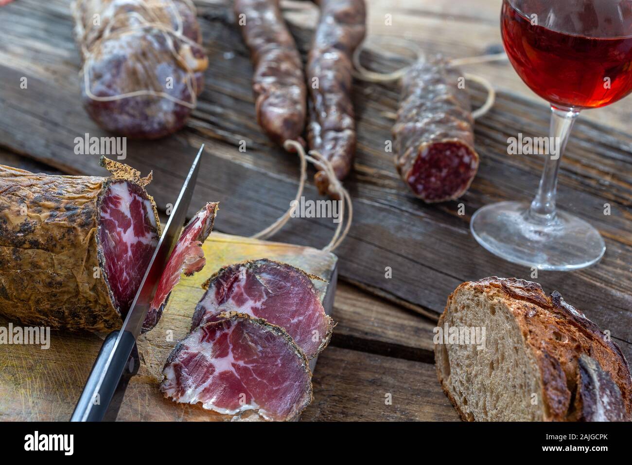 Korsische wild Schwein Feinkost und Käse in Korsika Frankreich auf hölzernen Hintergrund mit Glas Rot korsischen Wein Stockfoto